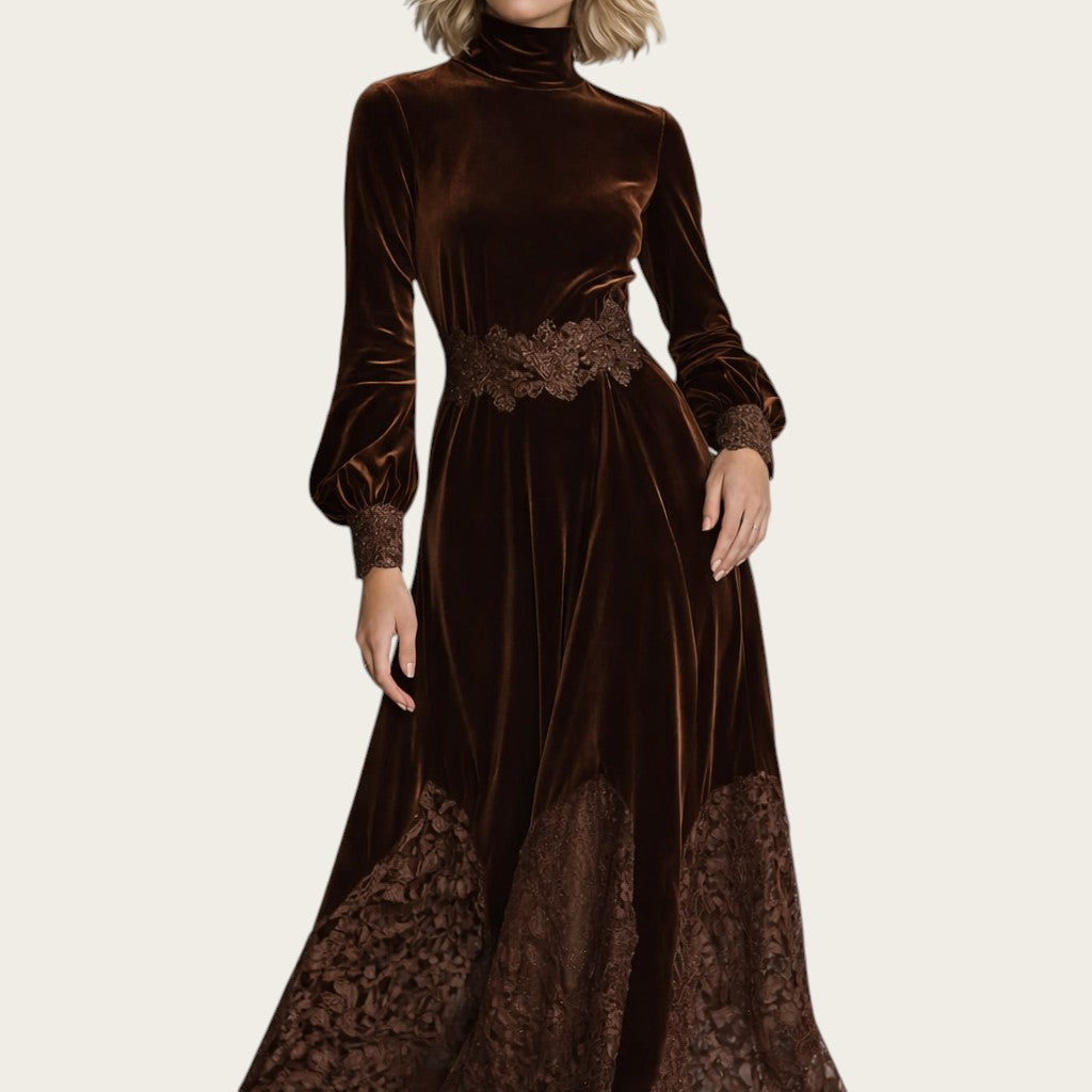 Vestido maxi de terciopelo marrón de Victoria Lemaire con cuello alto, mangas abullonadas y detalles de encaje patchwork.