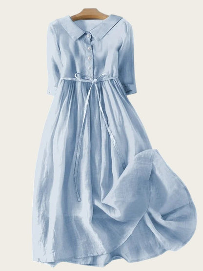 Vestido midi azul claro de Victoria Lemaire con cuello camisero, lazada en la cintura y manga larga.