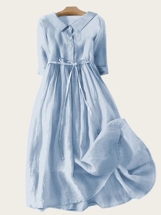 Vestido midi azul claro de Victoria Lemaire con cuello camisero, lazada en la cintura y manga larga.