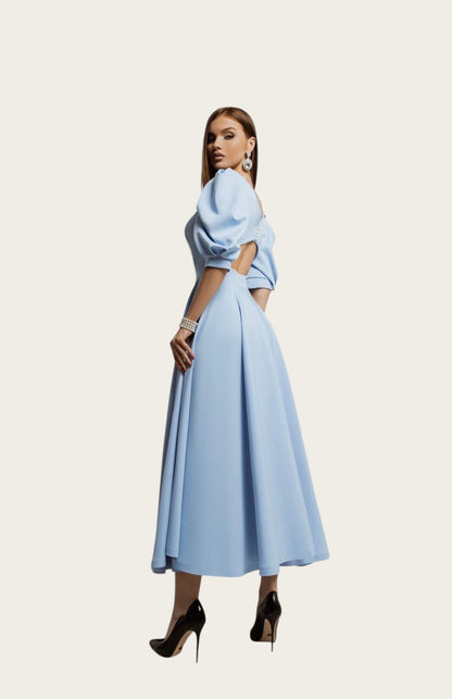 Vestido midi evasé azul claro de Victoria Lemaire con mangas abullonadas y botones perlados. Ideal para eventos.